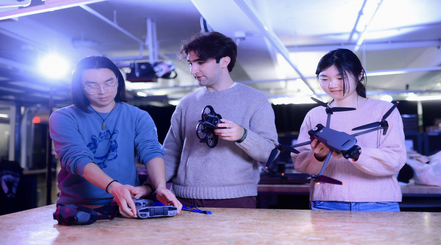 Three students holding VR headsets