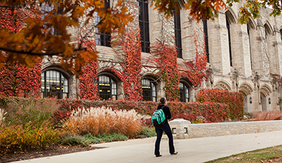 student walking in front of Deering Library
