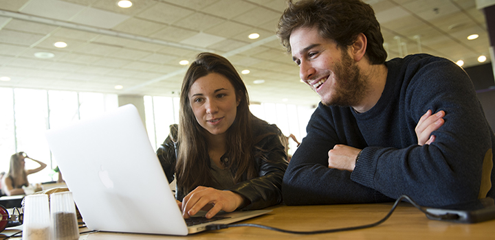 two students working together on a laptop