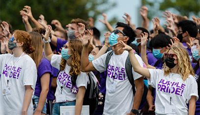 masked students in purple pride shirts giving wildcat claw
