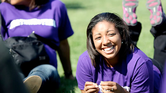 Student sitting outside in the grass